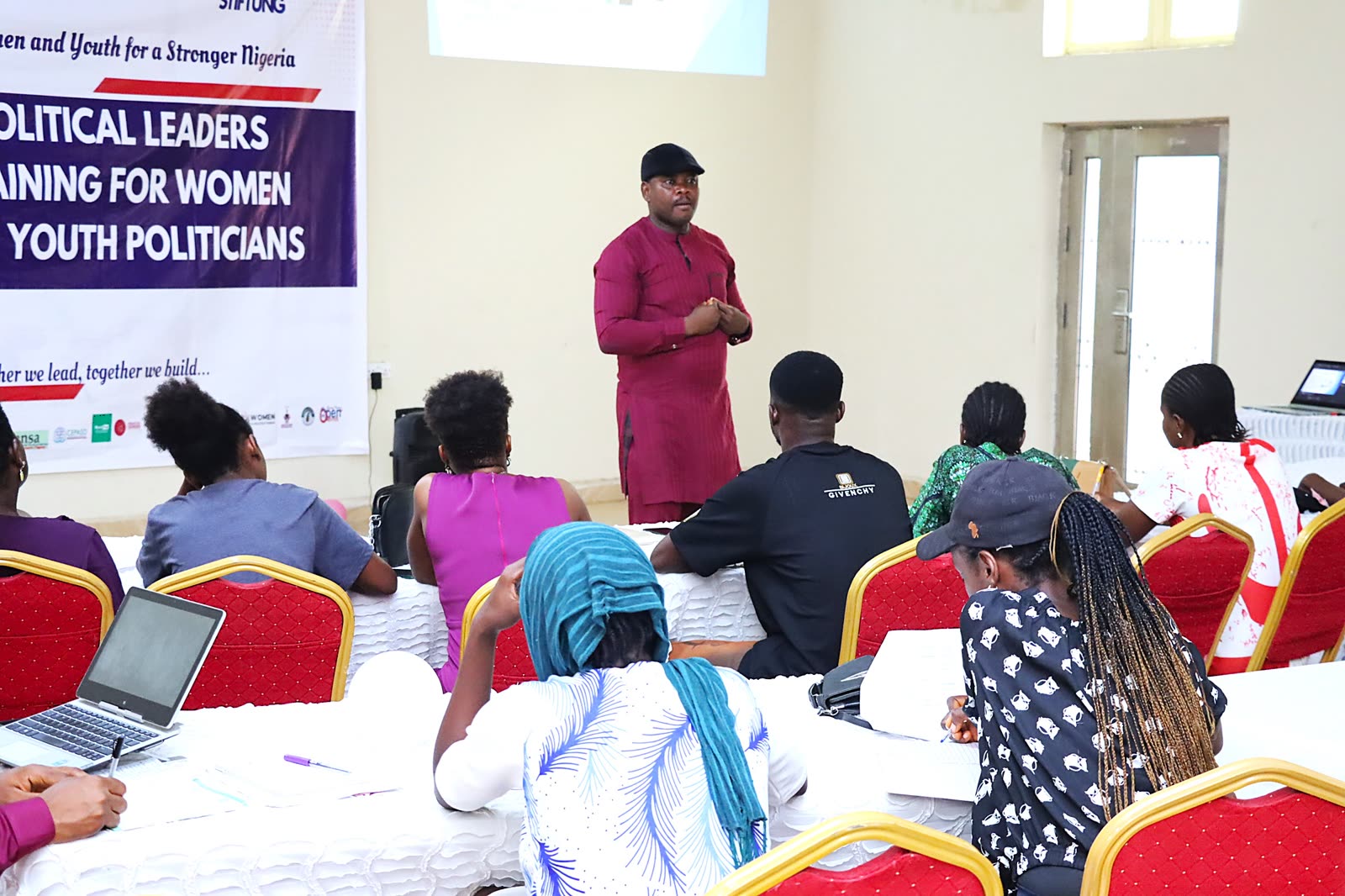 A facilitator addressing a full room at the Political Leaders Training for Women and Youth Politicians